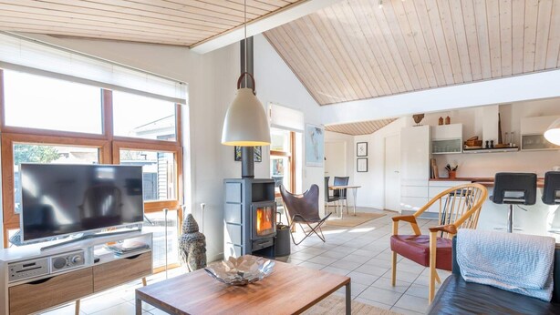 A modern living room with a TV, wooden coffee table, and a fireplace. - 5 Star Holiday Home in Fano (Fano)