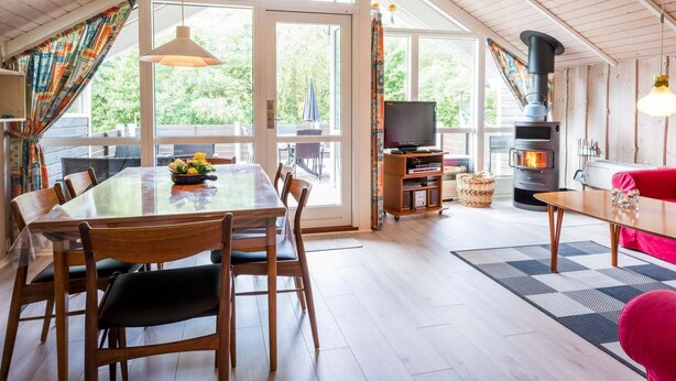 Un intérieur de chalet chaleureux comprenant un coin repas, un salon et une cheminée.