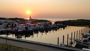 Un port de plaisance avec des bateaux amarrés au quai au coucher du soleil.