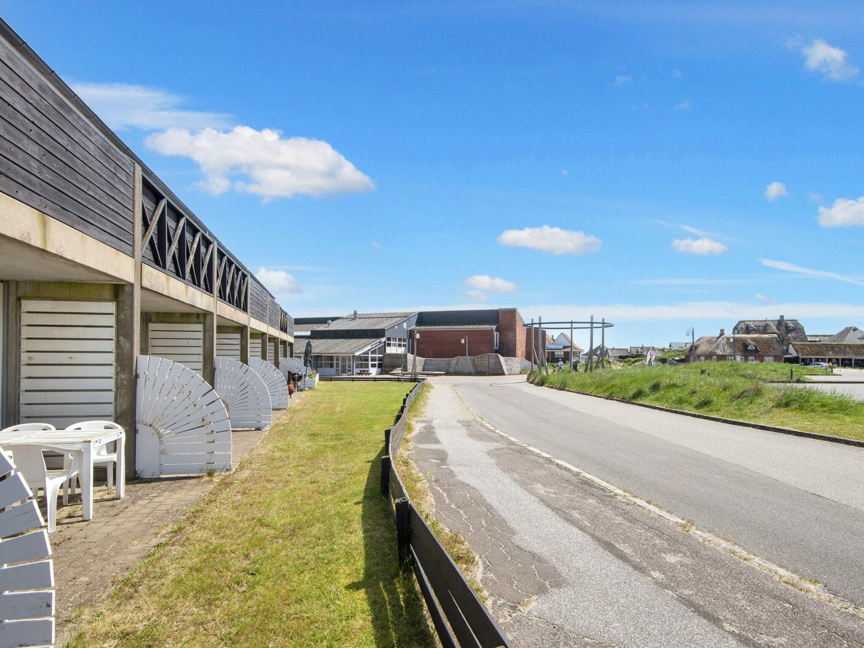 A building with a flat roof and a large open area in front.