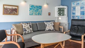 A cozy living area with a sofa, a round table, and a cabinet. - 4 Person Holiday Home in Fano (Fano)