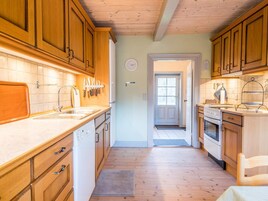 Una cocina con armarios de madera, un fregadero y una estufa.