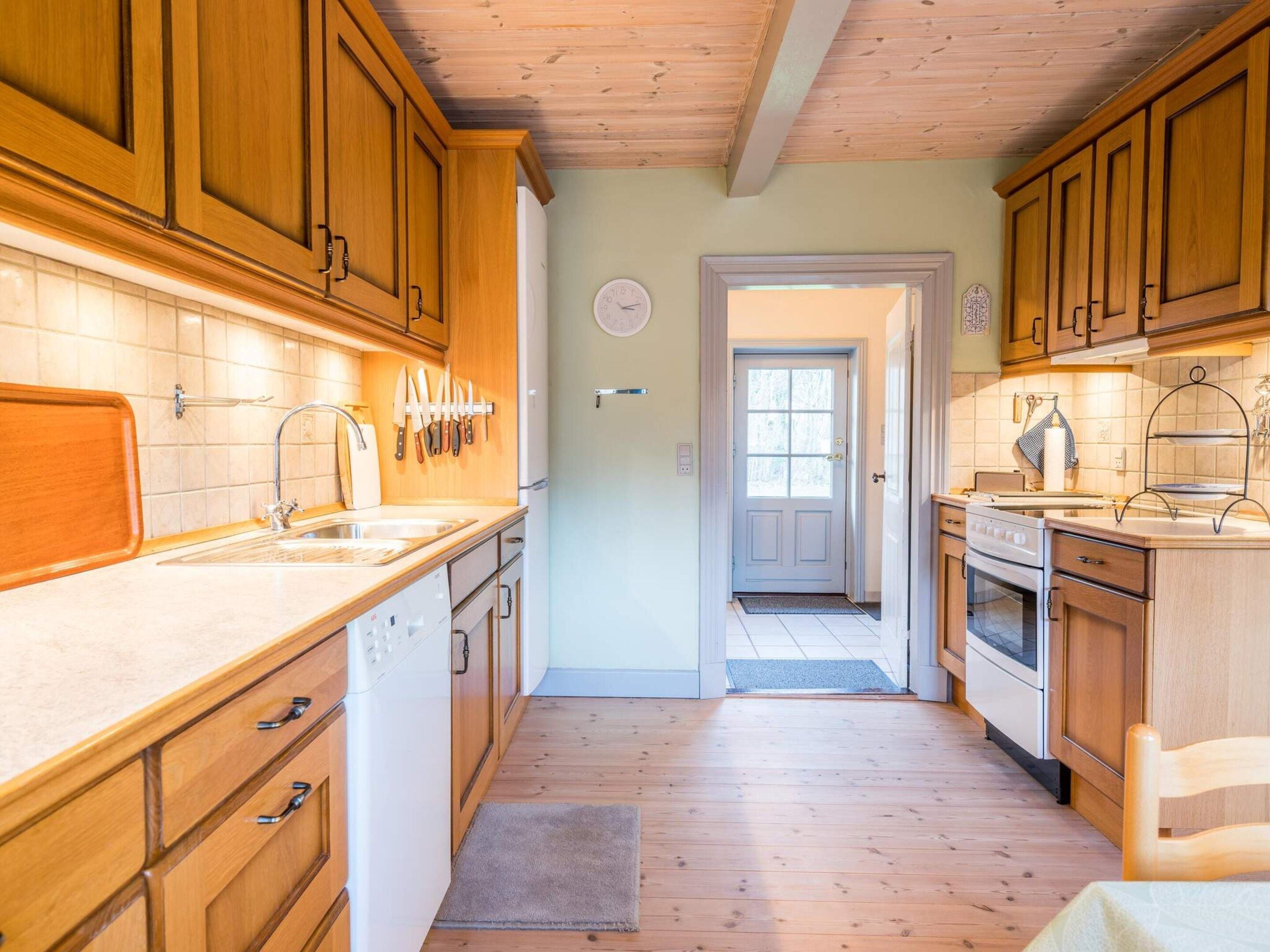 Una cocina con armarios de madera, un lavamanos y una estufa.