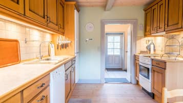 Una cocina con armarios de madera, un lavamanos y una estufa.