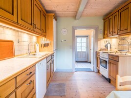 Una cocina con armarios de madera, un lavamanos y una estufa.