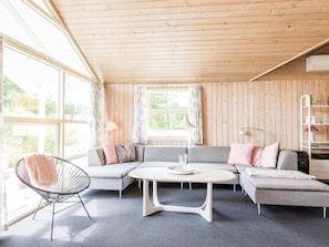 A modern living room with a sectional sofa, a round coffee table, and a chair.