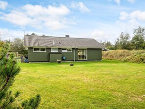A single-story house with a tiled roof, a front porch, and a well-maintained lawn. - 6 Person Holiday Home in Blavand (Blavand)