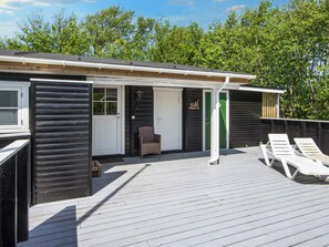 A wooden deck with two lounge chairs, a covered patio area, and a door leading to a room. - 5 Person Holiday Home in Fano (Fano)