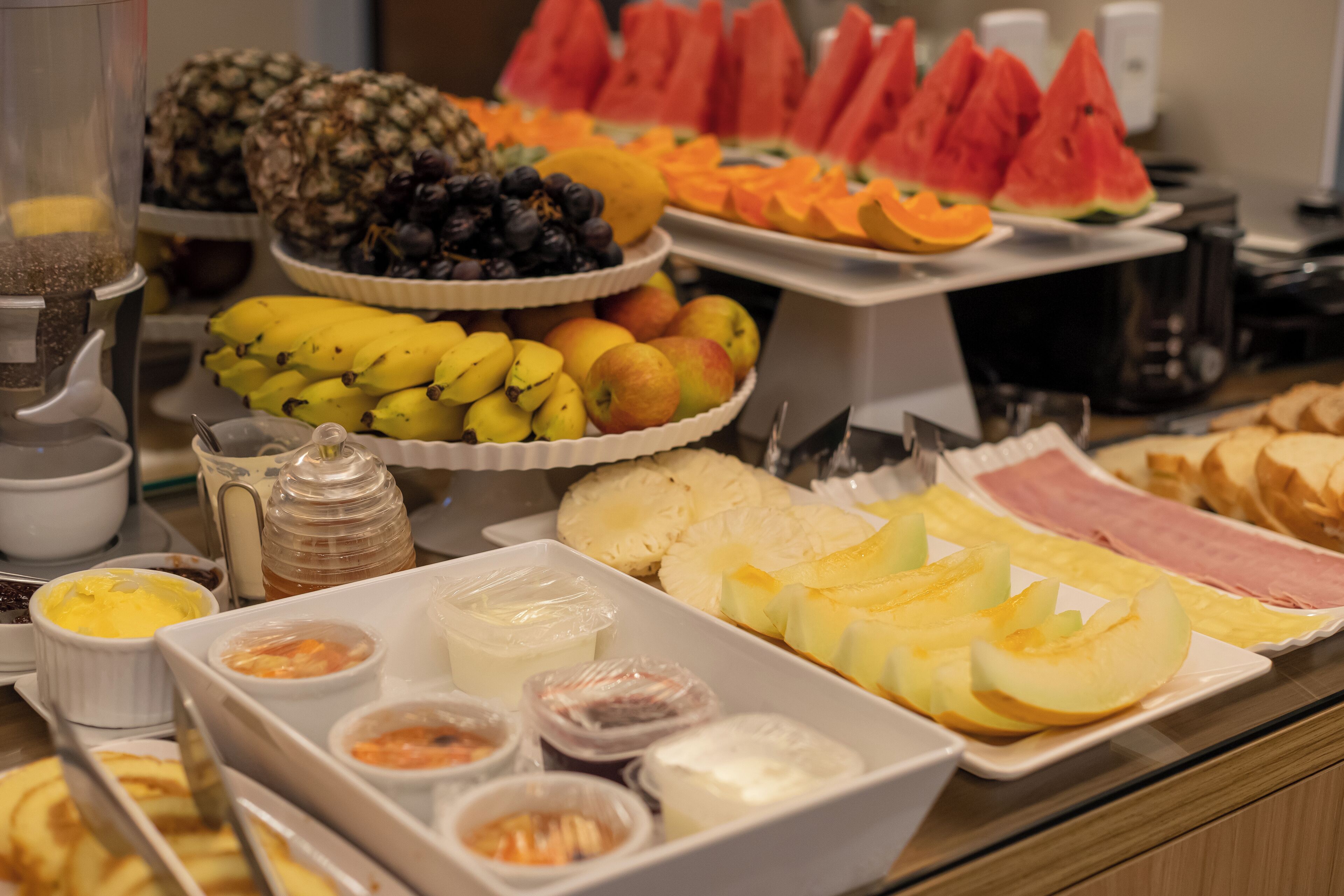 A buffet with various fruits, vegetables, and condiments.