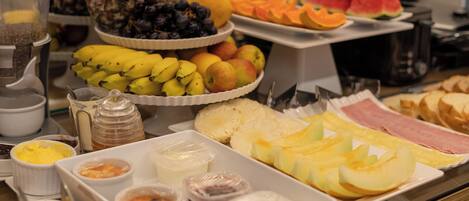 A buffet with various fruits, vegetables, and condiments.
