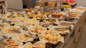 A buffet with various food items and utensils.