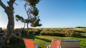 A wooden deck with two orange chairs facing a beach view. - Beachfront! Walk the short path to the Beach, or enjoy the waves from the Deck (Rockaway Beach)