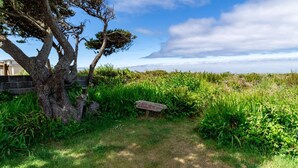 A natural landscape with a sign reading "BEACH" in the foreground, surrounded by lush greenery and a tree. - Beachfront! Walk the short path to the Beach, or enjoy the waves from the Deck (Rockaway Beach)