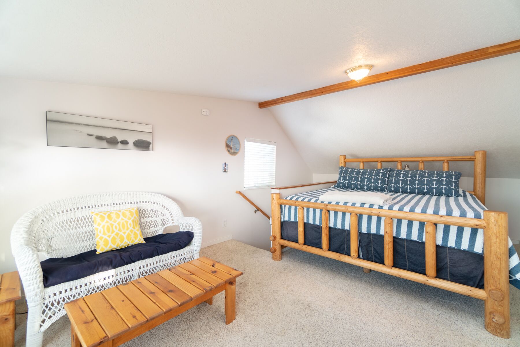 Ein gemütliches Zimmer mit einem hölzernen Bett, einem Korbsessel und einem kleinen Holztisch.
