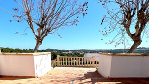 A terrace with tiled flooring, a wooden railing, and two trees. - 0356 Monte Javea Calicanto (Javea / Xàbia)