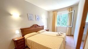 A hotel room with a bed, bedside tables, a lamp, and a window with curtains. - 0356 Monte Javea Calicanto (Javea / Xàbia)