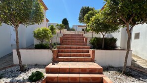 A set of terracotta steps leading up to a white building, surrounded by small trees and gravel. - 0361 Villa Monte Javea Laurel (Javea / Xàbia)