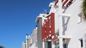 Un bâtiment moderne doté d’un toit plat, de murs blancs et d’éléments décoratifs rouges.
