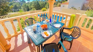 Ein Balkon mit Tisch für zwei Personen, mit Blick auf eine schöne Landschaft.