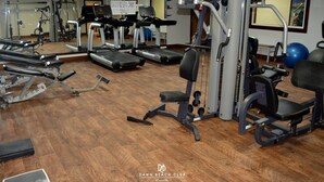 Un gimnasio con cintas de correr, máquinas de pesas y pelotas de ejercicio.