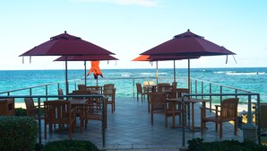 An outdoor seating area with tables and chairs, overlooking the ocean. - Building A- Condo - Direct Ocean Front Views...directly on the beach. (Sint Maarten)