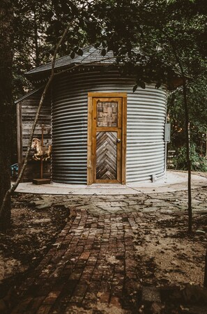 A rustic cabin with a wooden door and a herringbone-patterned window.
