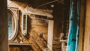 Un intérieur rustique en bois, agrémenté d’une vieille machine à laver sur laquelle on peut lire l’inscription « Service de blanchisserie de luxe ».