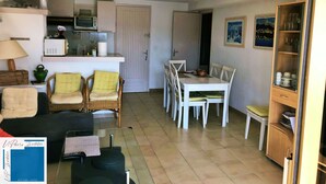 A compact living space with a kitchenette, dining area, and seating.