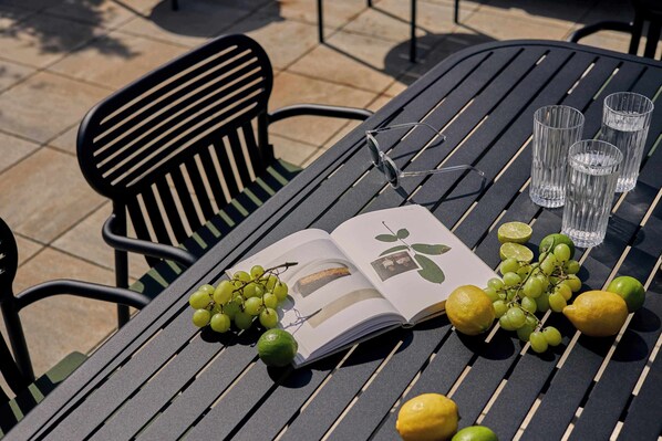 Una mesa con un libro, gafas y frutas.