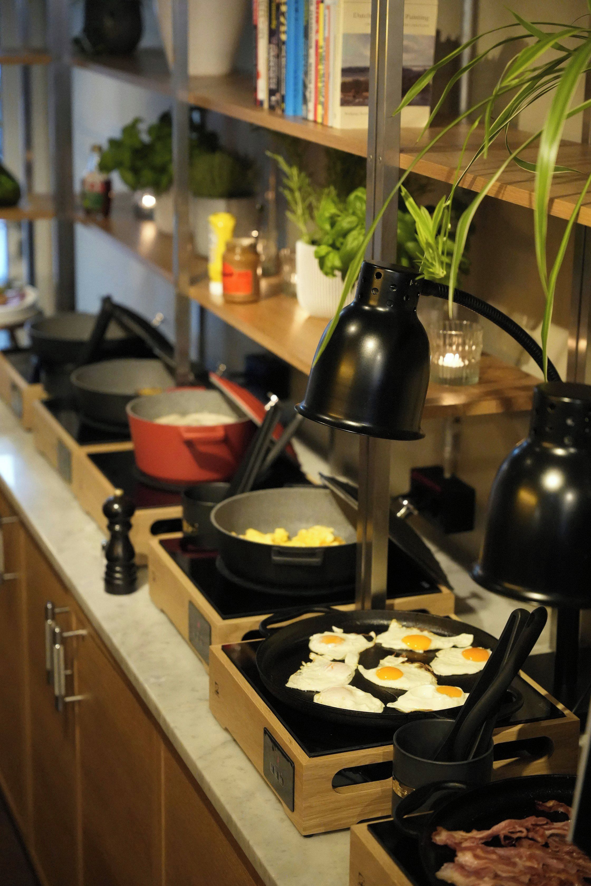 A kitchen counter with cooking utensils, a frying pan, and a pot.