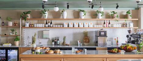 Una cocina moderna con una isla central, electrodomésticos integrados y plantas decorativas.