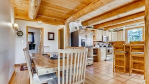 A wooden interior with a dining area, kitchen, and bunk beds. - Private Hot Tub in the Aspens - Steam Shower, Log Fireplace, Mtn Views (Alma)