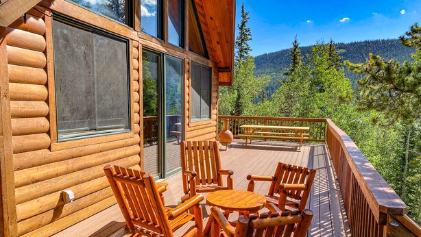 A wooden deck with outdoor furniture, large windows, and a scenic mountain view. - Private Hot Tub in the Aspens - Steam Shower, Log Fireplace, Mtn Views (Alma)