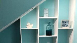 Una cocina con armarios blancos, encimera de granito y salpicadero color turquesa.