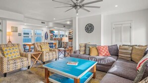 Ein modernes Wohnzimmer mit Deckenventilator, Couchtisch und Sofa.