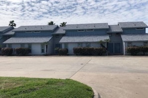 A row of multi-story buildings with a parking lot in front. - Island Dunes Condo's-#1109-One Block from Beach. (Port Aransas)