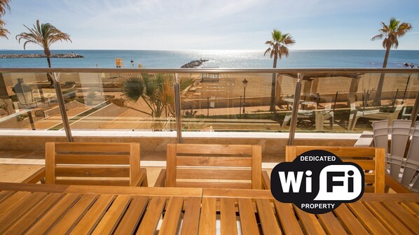 Une terrasse en bois offrant une vue sur la plage et l’océan.