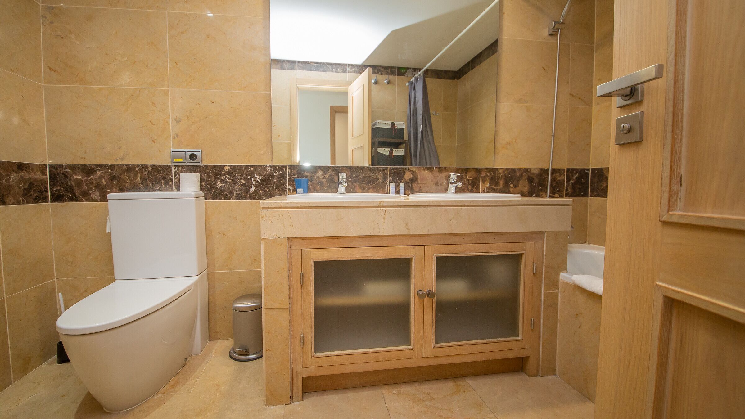 Een badkamer met toilet, wastafel en douche.