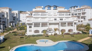Un hotel a più piani con piscina, balconi e area giardino.
