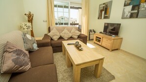 Ein modernes Wohnzimmer mit einem braunen Sofa, einem Holztisch und einem Fernsehschrank.