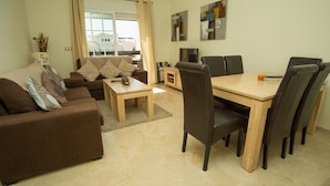 Ein Wohnzimmer mit einer Couch, einem Couchtisch und einem Essbereich mit Tisch und Stühlen.