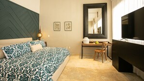 Een slaapkamer met een bed, een bureau, een stoel, een televisietoestel en een open haard.