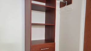 Un armario de madera con tres cajones y una barra para colgar.
