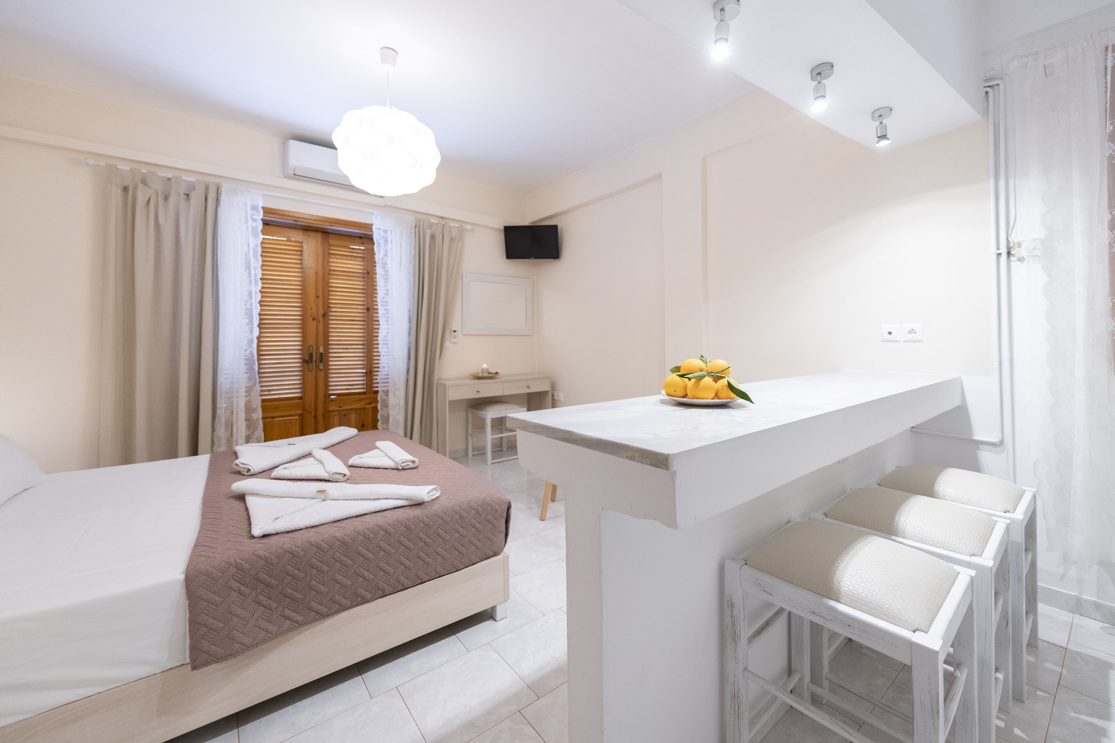 Une chambre d’hôtel moderne équipée d’un lit, d’un bureau et d’un petit coin salon.