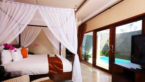Une chambre avec un lit à baldaquin, une télévision et une vue sur une piscine.