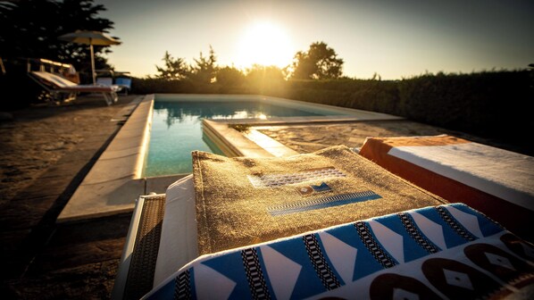 Ein Poolbereich mit Liegestühlen und einer Sonnenliege.