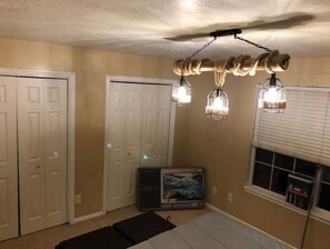 Comfortable room with a television, closet, and window with blinds.