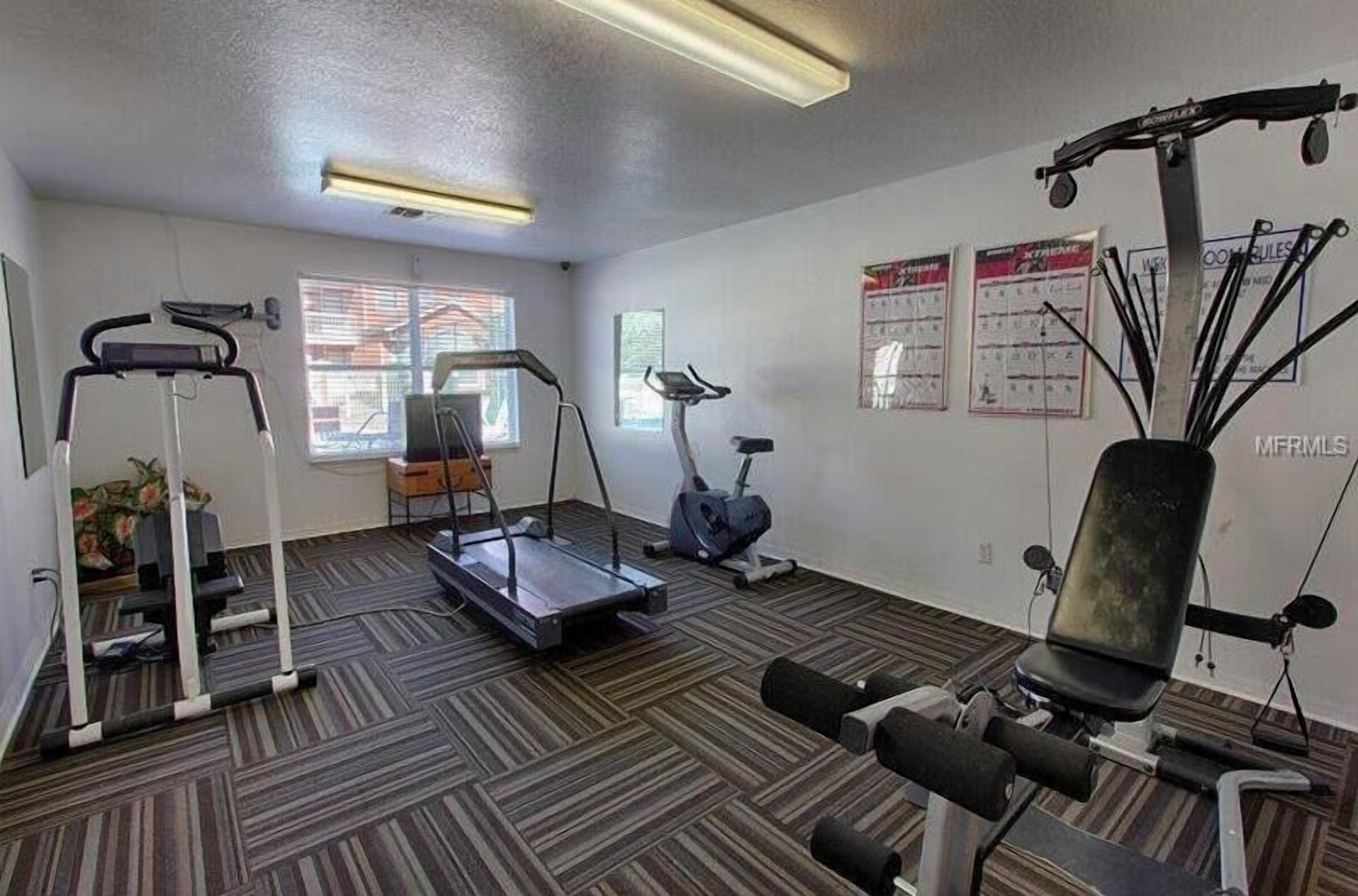 Ein Fitnessstudio mit Laufbändern, Crosstrainern und Krafttrainingsgeräten.