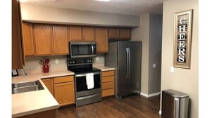 A kitchen with wooden cabinets, stainless steel appliances, a microwave, oven, and refrigerator. - Your Second Home. Big 2 Bedroom and 2 bathroom. (Clearfield)