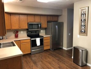 A kitchen with wooden cabinets, stainless steel appliances, a microwave, oven, and refrigerator. - Your Second Home. Big 2 Bedroom and 2 bathroom. (Clearfield)
